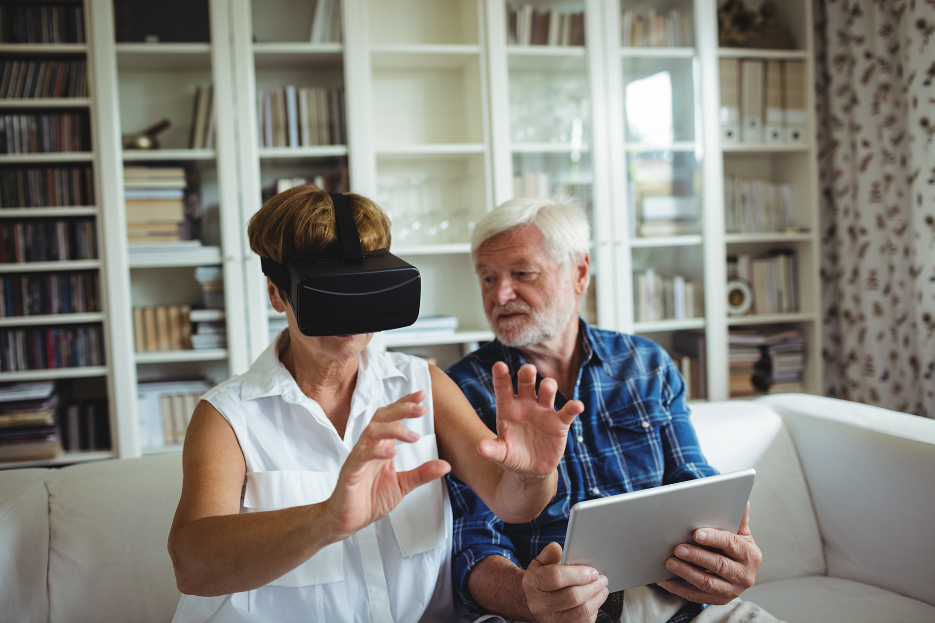 An older couple using a VR headset, which may help improve cognitive function